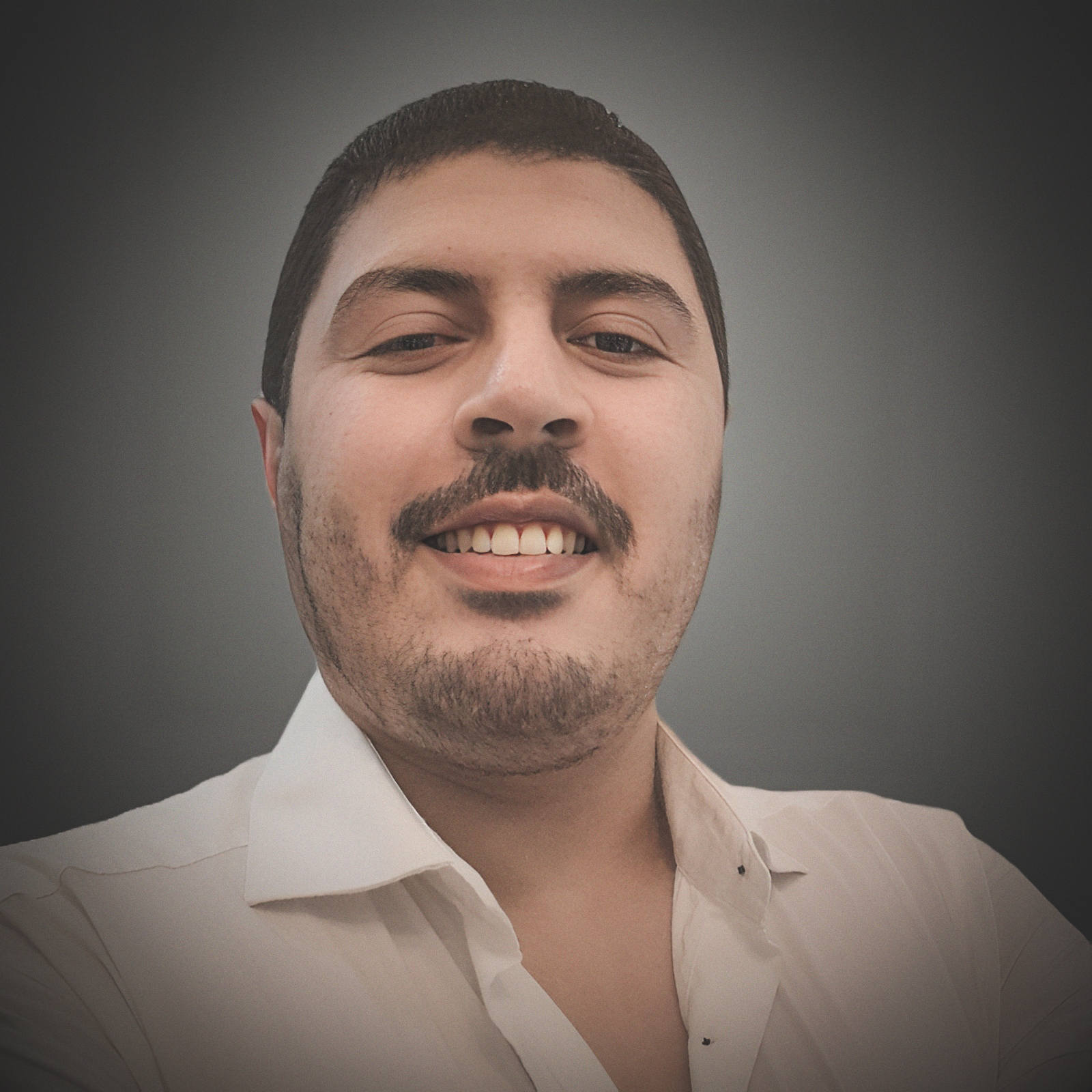 Smiling Anas Jafir facing forward, wearing a casual shirt, neutral background, professional and approachable mood